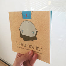 Life's Not Fair book being held